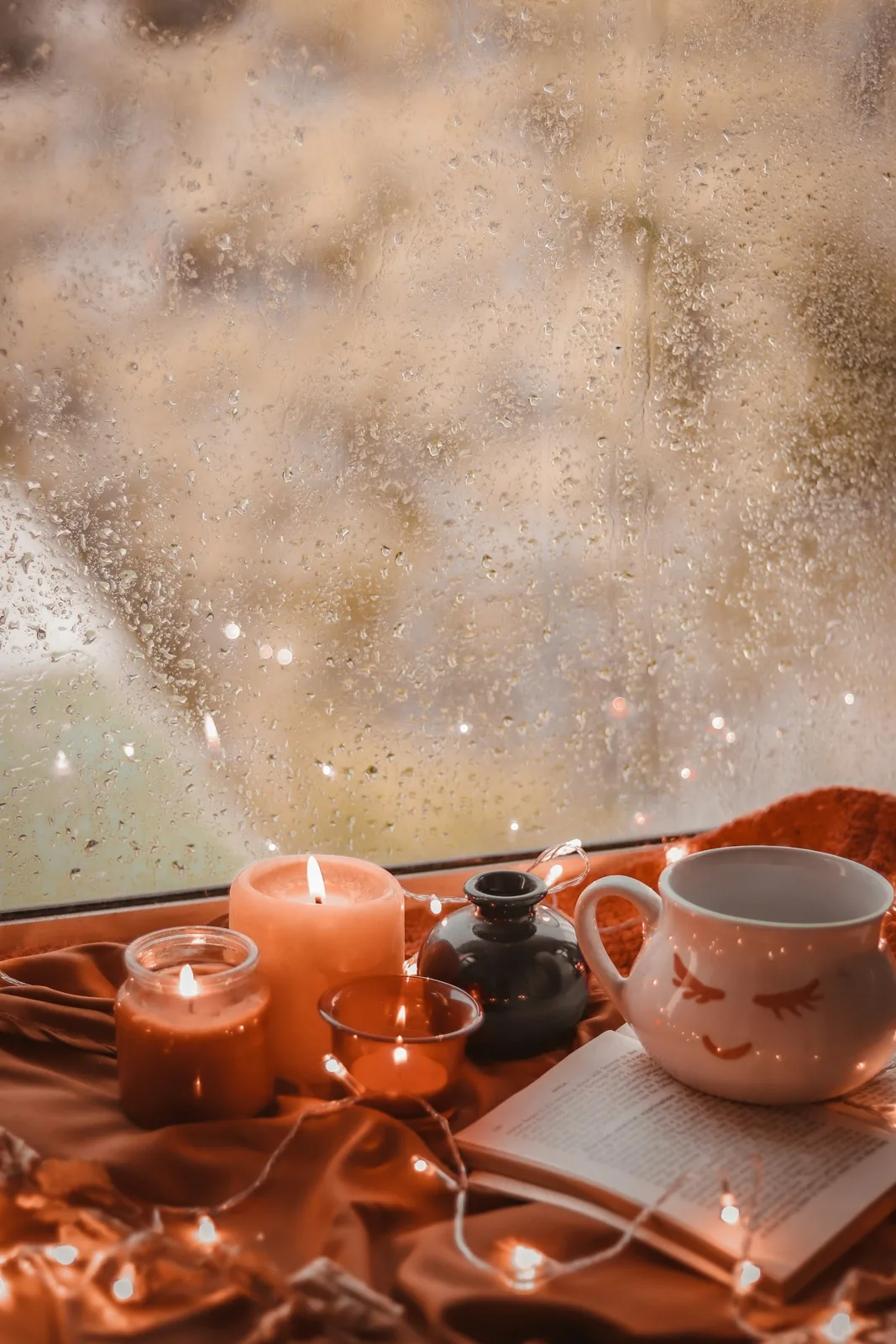 A cup beside a rain-streaked window, with warm autumn details.