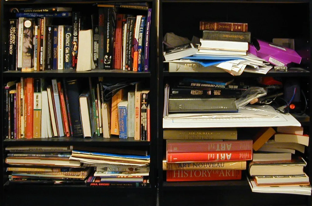 A crowded bookcase with upright books and several horizontal stacks.