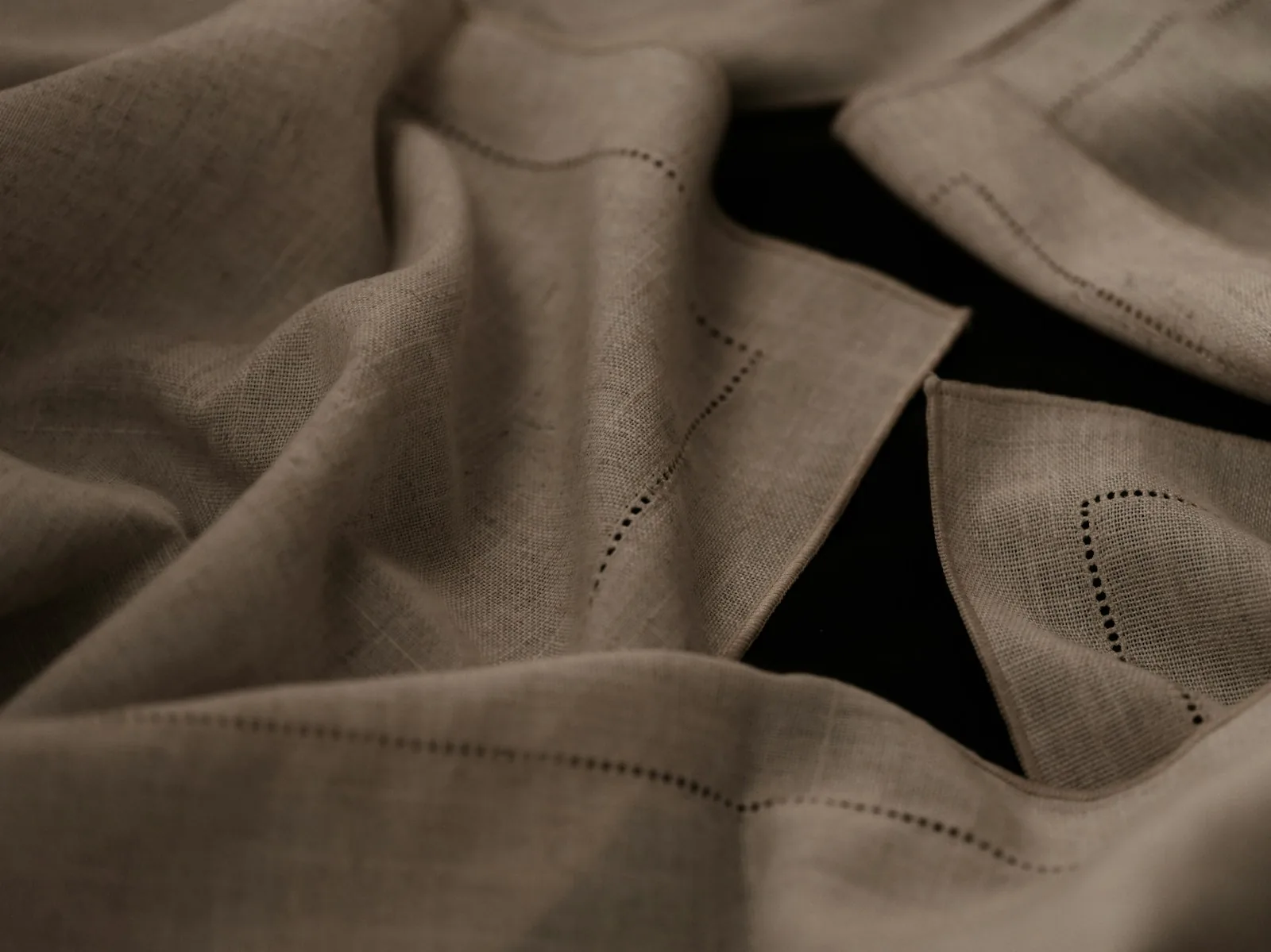 Folded linen napkins showing their weave and soft edges.