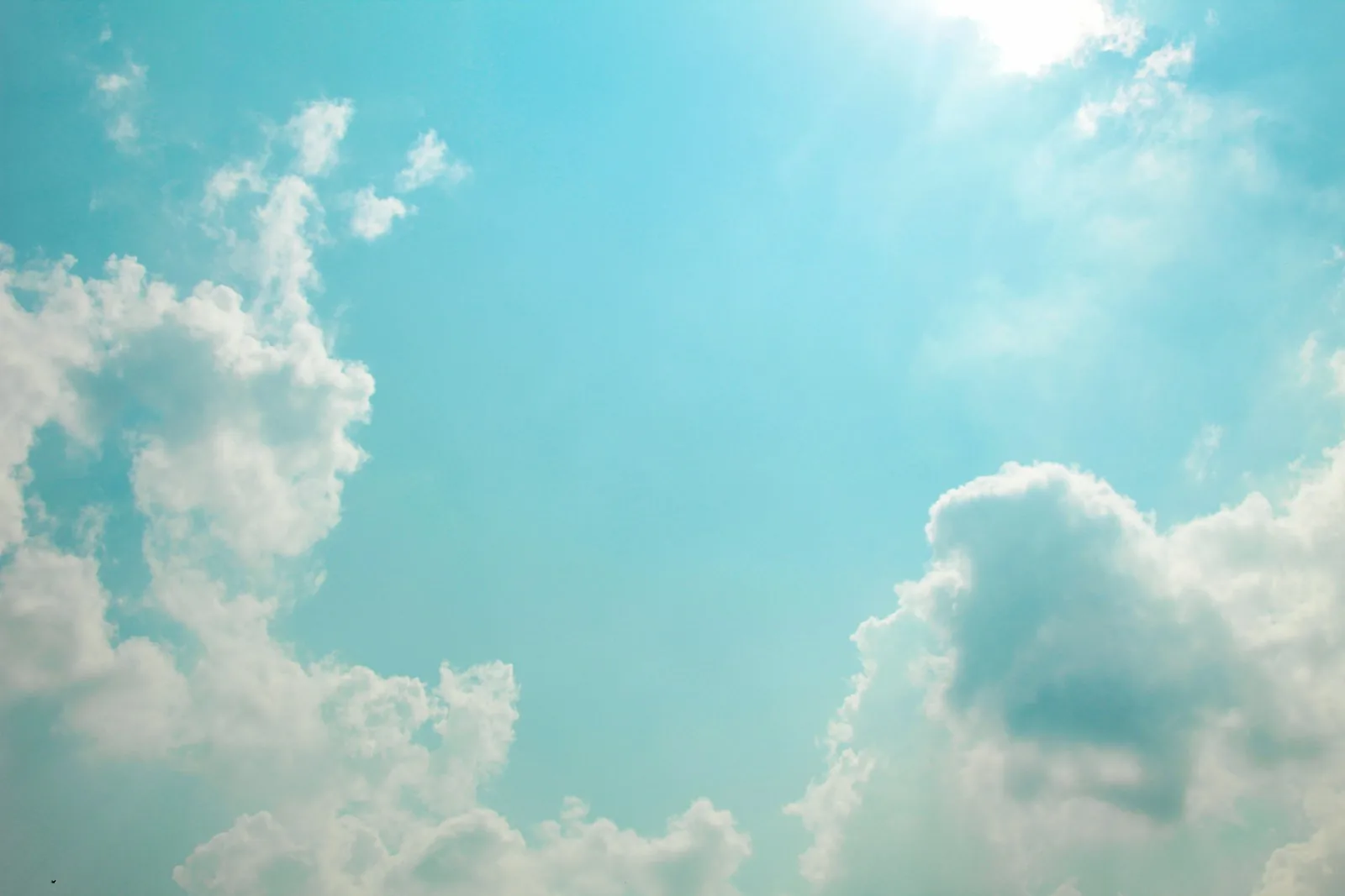 White cloud forms spread across a blue sky.